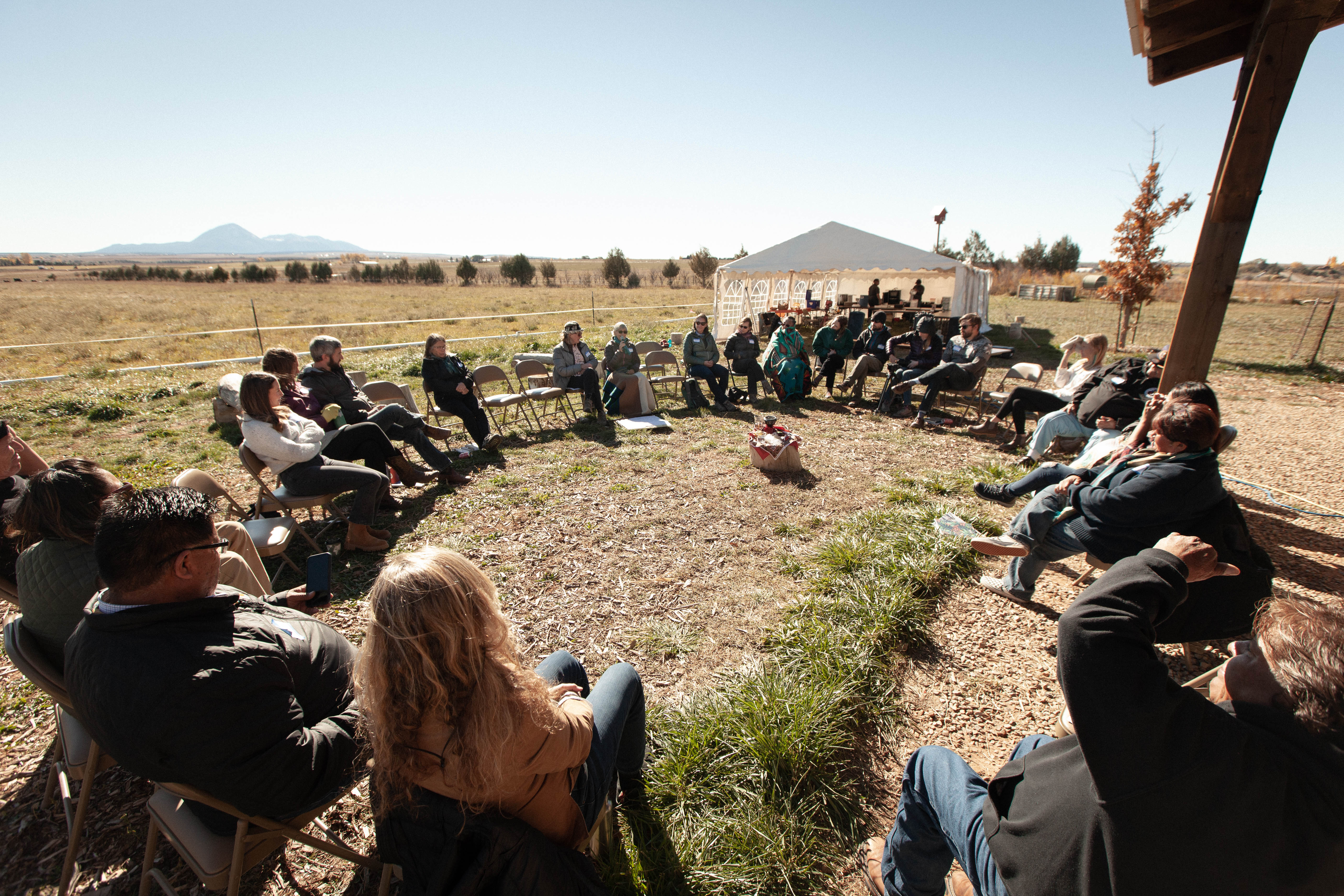 Event attendees sit in a circle sharing stories with one another.