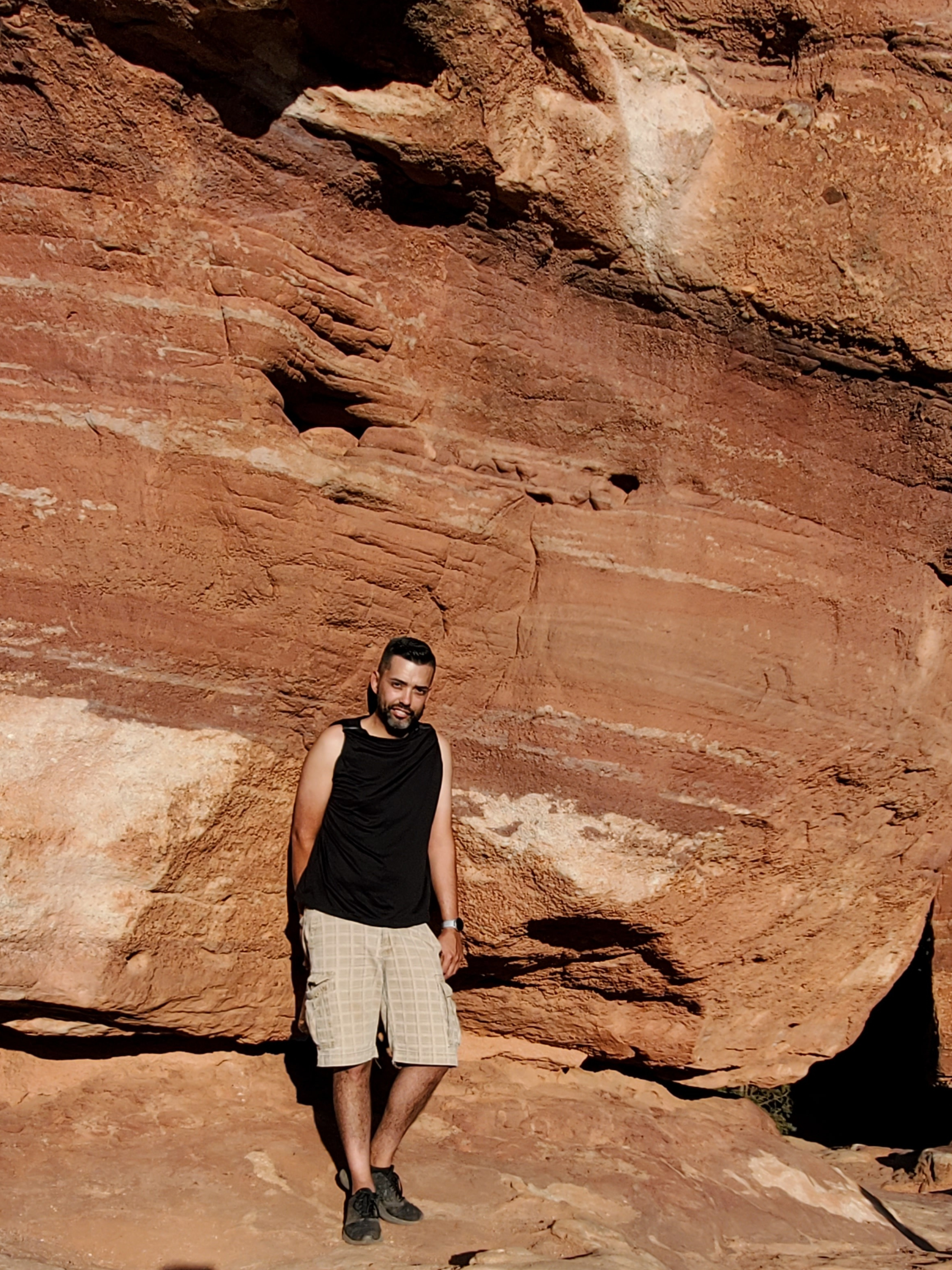 Jonathan Silva posing for a photo outdoors in front a big red rock