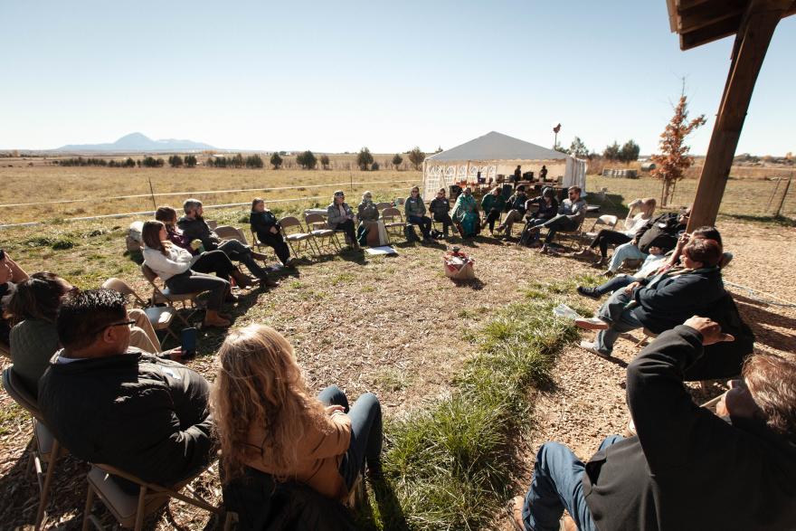 Event attendees sit in a circle sharing stories with one another. 